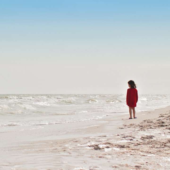 девушка стоит на берегу моря в дневное время онлайн-пазл