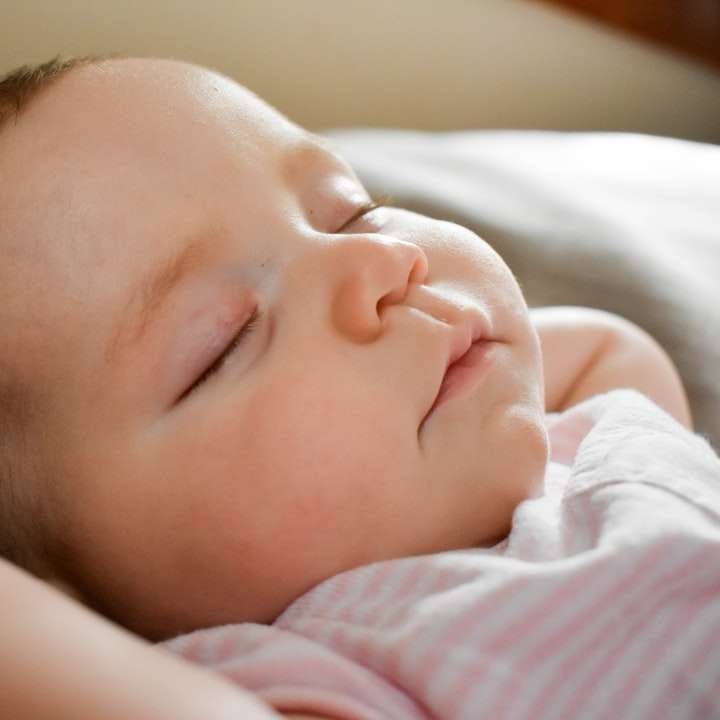 śpiące dziecko na szarej poduszce puzzle przesuwne online