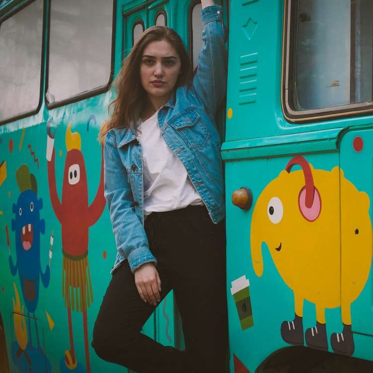 kobieta stojąca obok turkusowego autobusu puzzle przesuwne online
