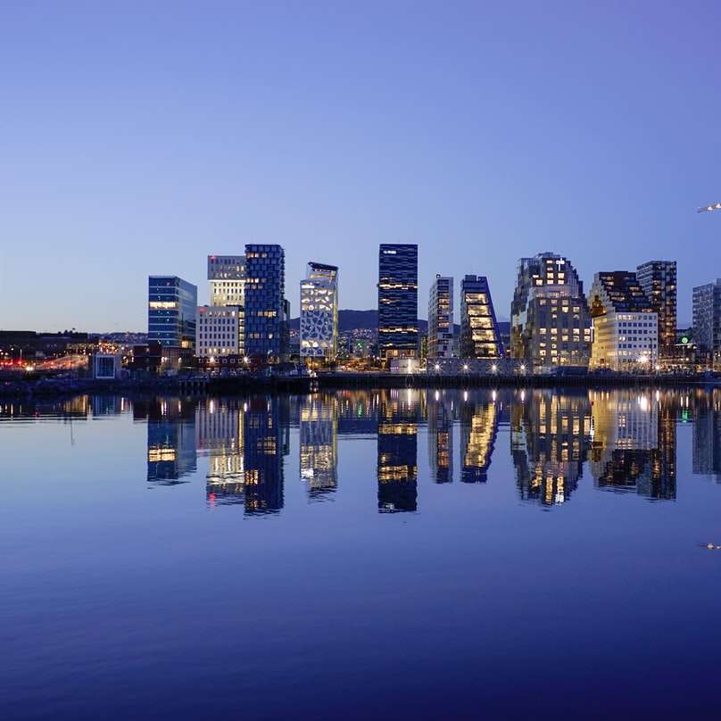 Stadtbild durch Wasser während der goldenen Stunde Schiebepuzzle online