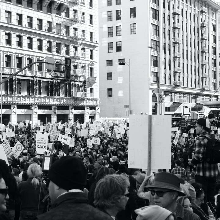Fotografía en escala de grises de personas que protestaban frente rompecabezas en línea