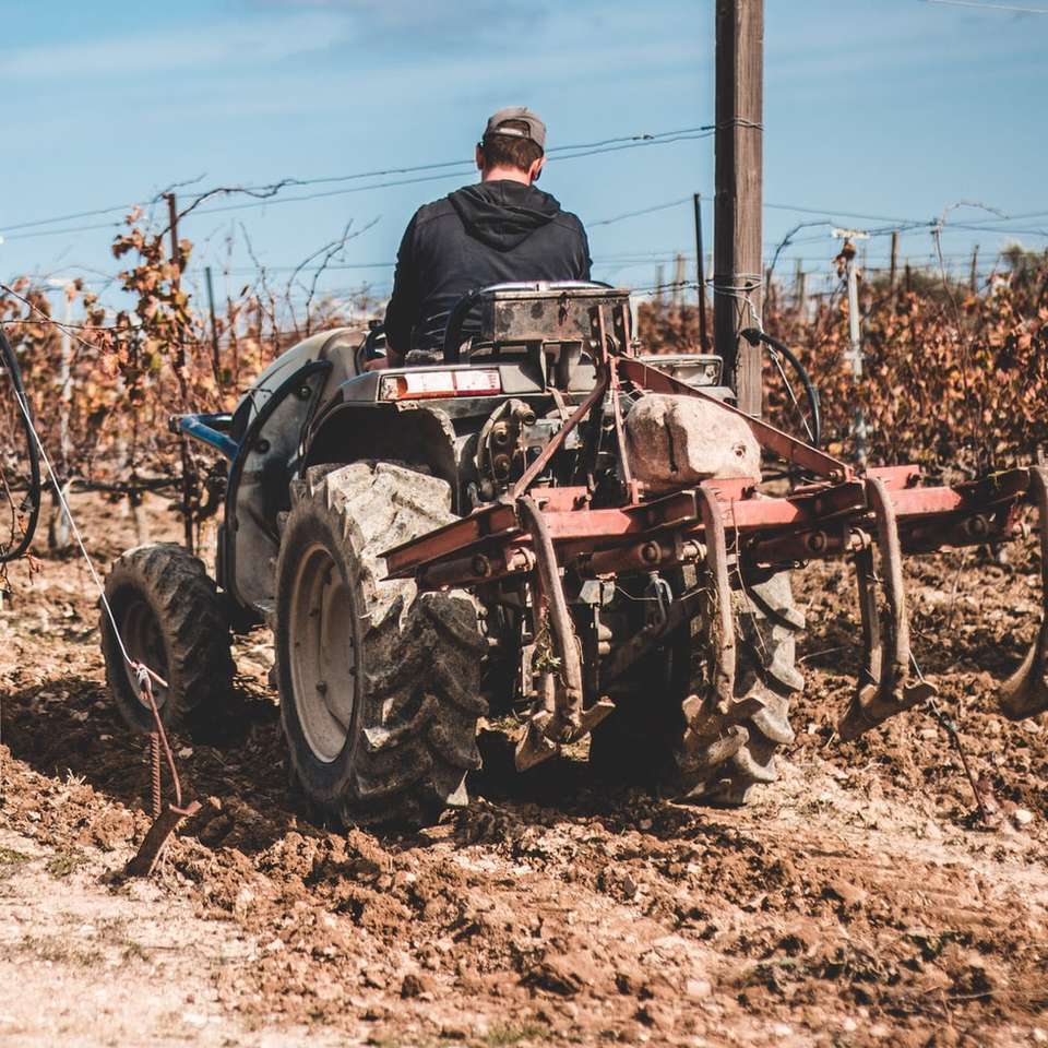 muž v černé bundě na červeném traktoru online puzzle