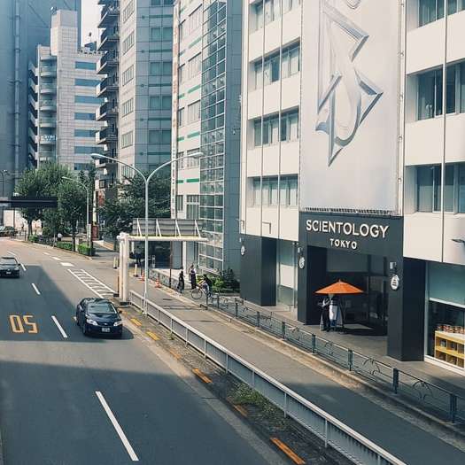 αυτοκίνητα στο δρόμο κοντά σε ψηλά κτίρια κατά τη διάρκεια της ημέρας συρόμενο παζλ online
