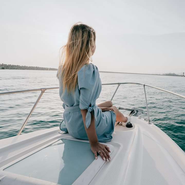 Femme en chemise à manches longues blanche assise sur un bateau blanc puzzle coulissant en ligne