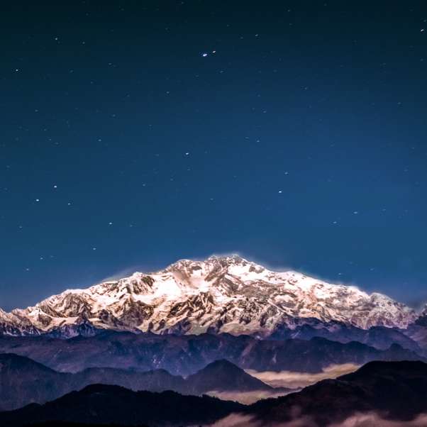 montagna coperta di neve sotto il cielo stellato puzzle online