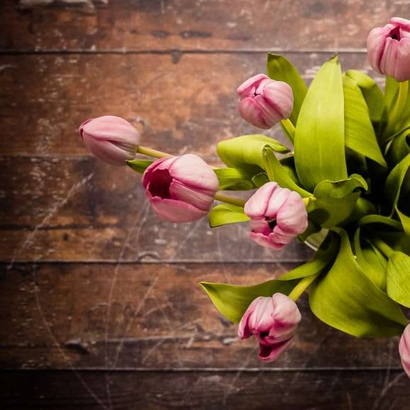 ροζ κεντρικό τεμάχιο λουλουδιών με πέταλα σε καφέ ξύλινη επιφάνεια online παζλ