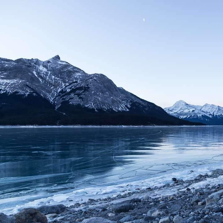 body of water surrounded with snowy mountain online puzzle