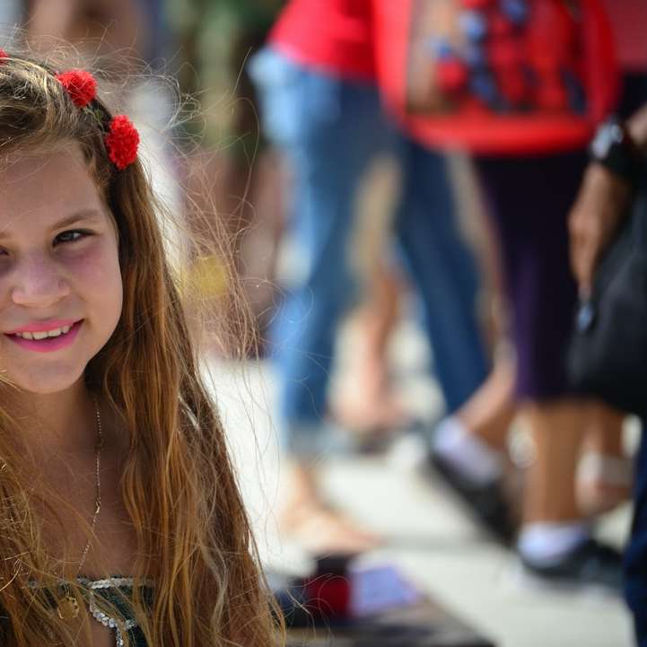 χαμογελαστό κορίτσι με κόκκινο λουλούδι κόμμωση συρόμενο παζλ online