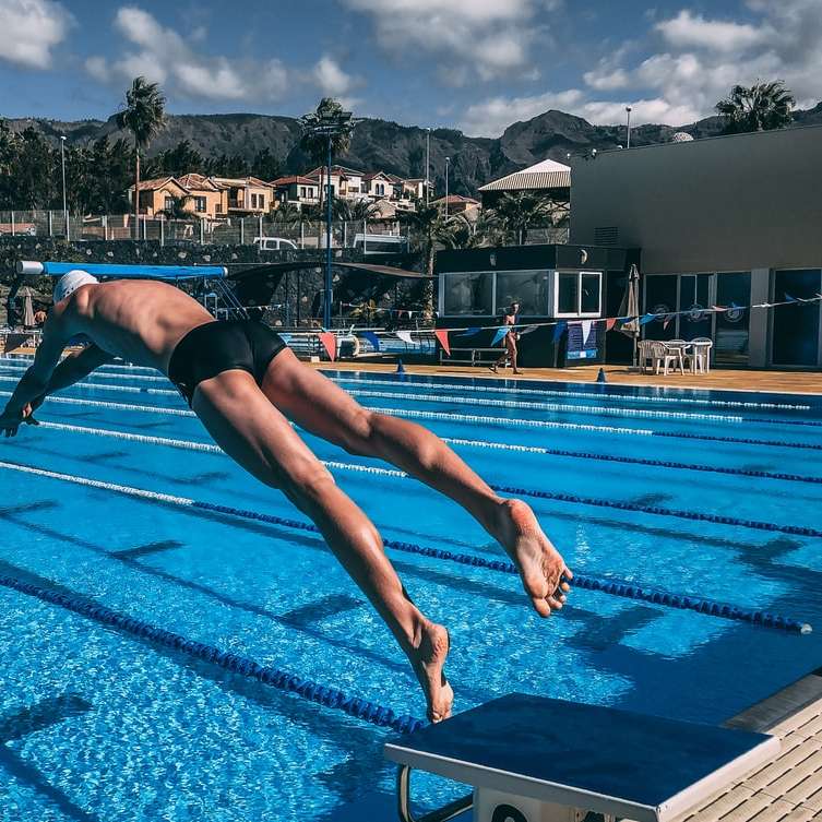 mężczyzna nurkujący w basenie w ciągu dnia puzzle przesuwne online