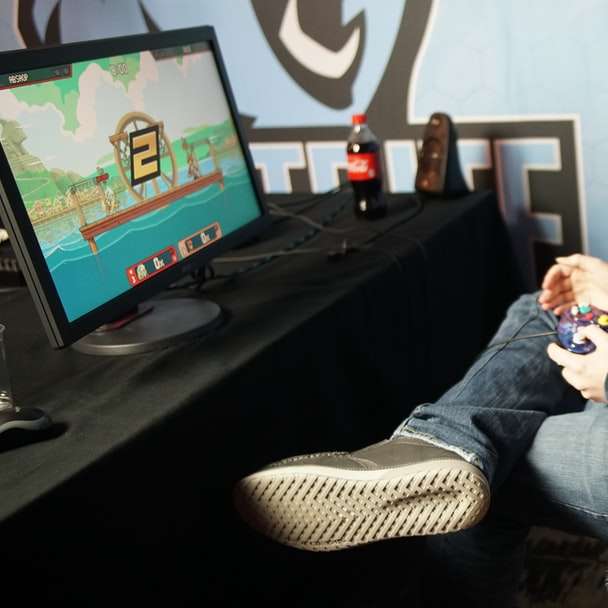 man sitting and playing video game using control pad online puzzle