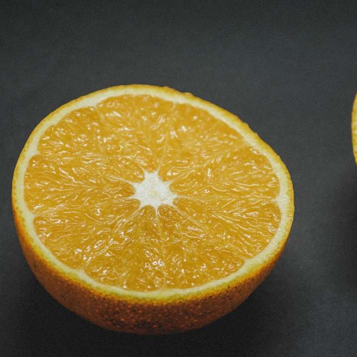 frutas cortadas de laranja em tecido preto puzzle online