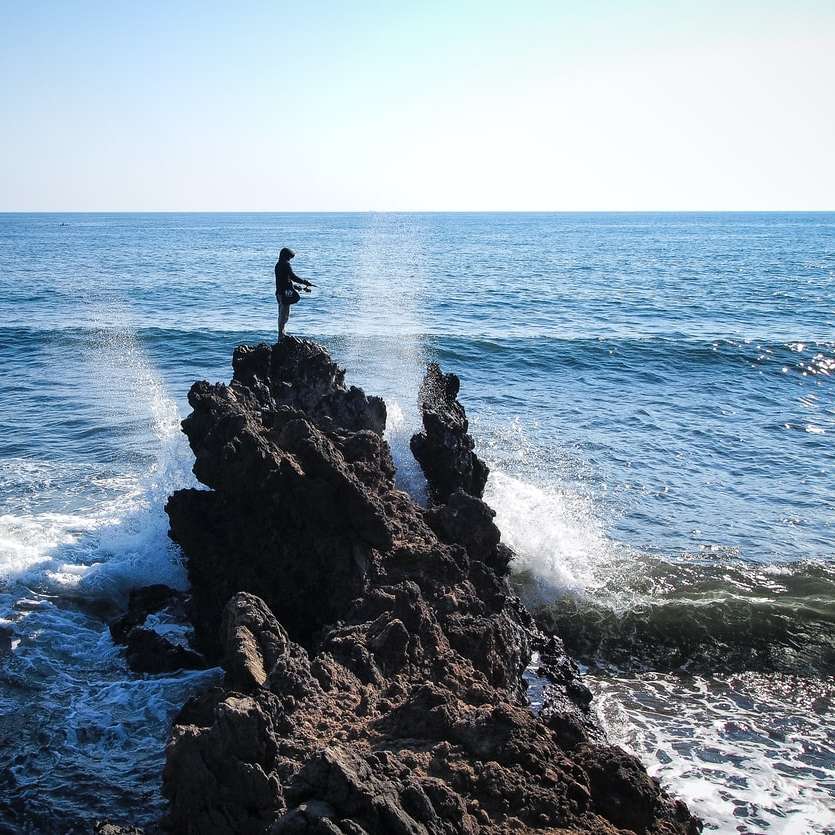 άντρας στέκεται πάνω σε βράχο συρόμενο παζλ online