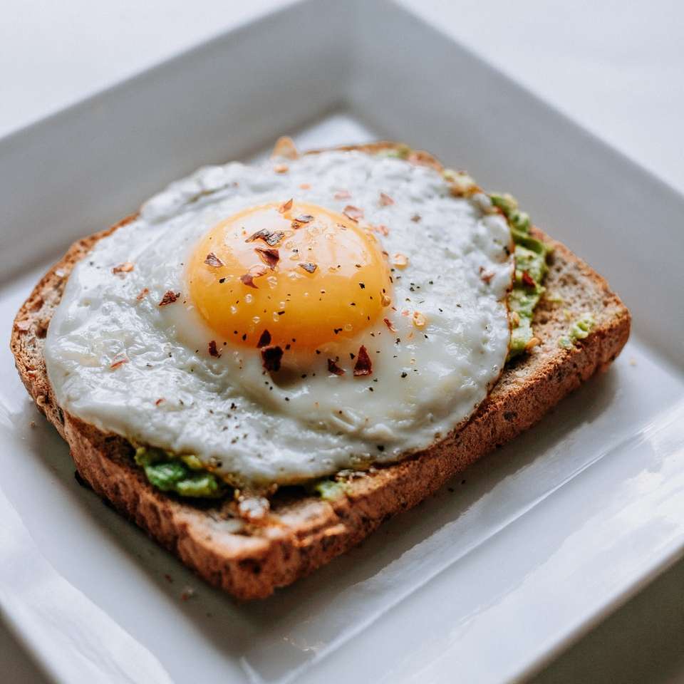 brood met zonnig kant-up ei dat op witte ceramische plaat wordt gediend schuifpuzzel online