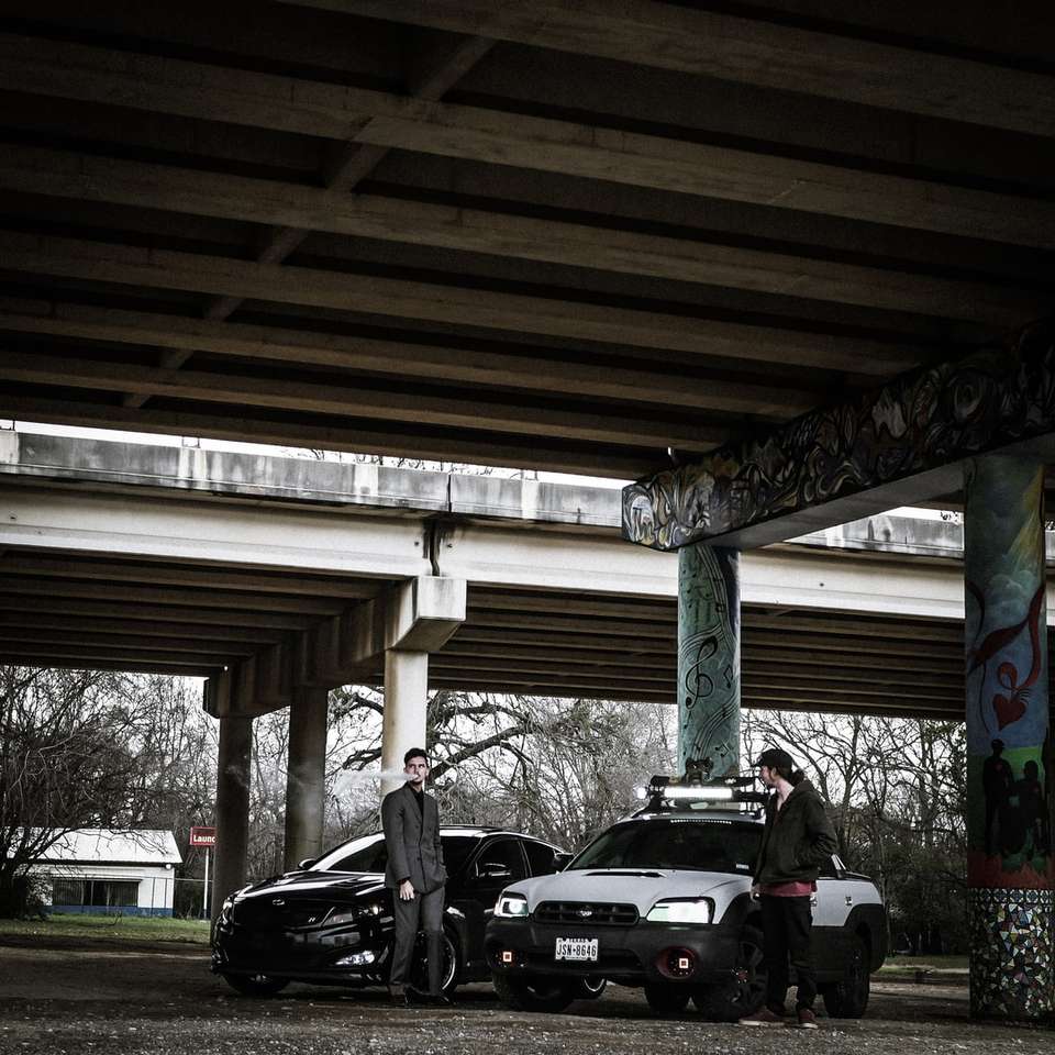 deux hommes debout près de voitures puzzle en ligne