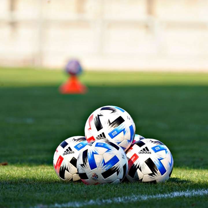 緑の芝生のフィールドに白青と赤のサッカーボール スライディングパズル・オンライン