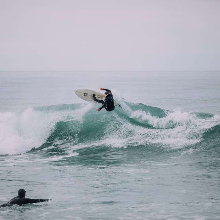 person som surfar på vågor glidande pussel online