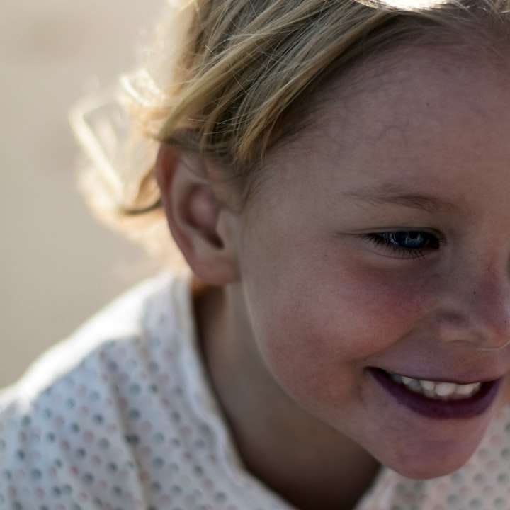 Foto de enfoque selectivo de joven niña sonriente rompecabezas en línea