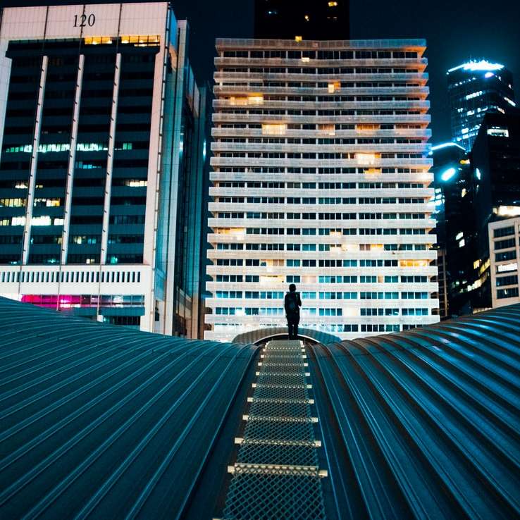 osoba stojąca na dachu budynku z budynkami miejskimi puzzle przesuwne online