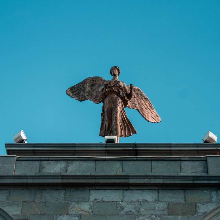 Estatua de hormigón marrón bajo un cielo azul durante el día rompecabezas en línea