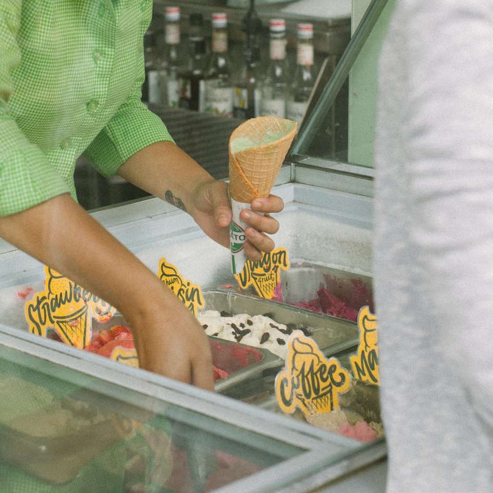 persona sosteniendo un cono de helado y sacando helado puzzle deslizante online