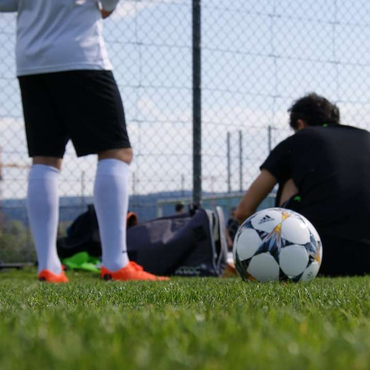 Mann im schwarzen T-Shirt und in den weißen Shorts, die Fußball spielen Online-Puzzle