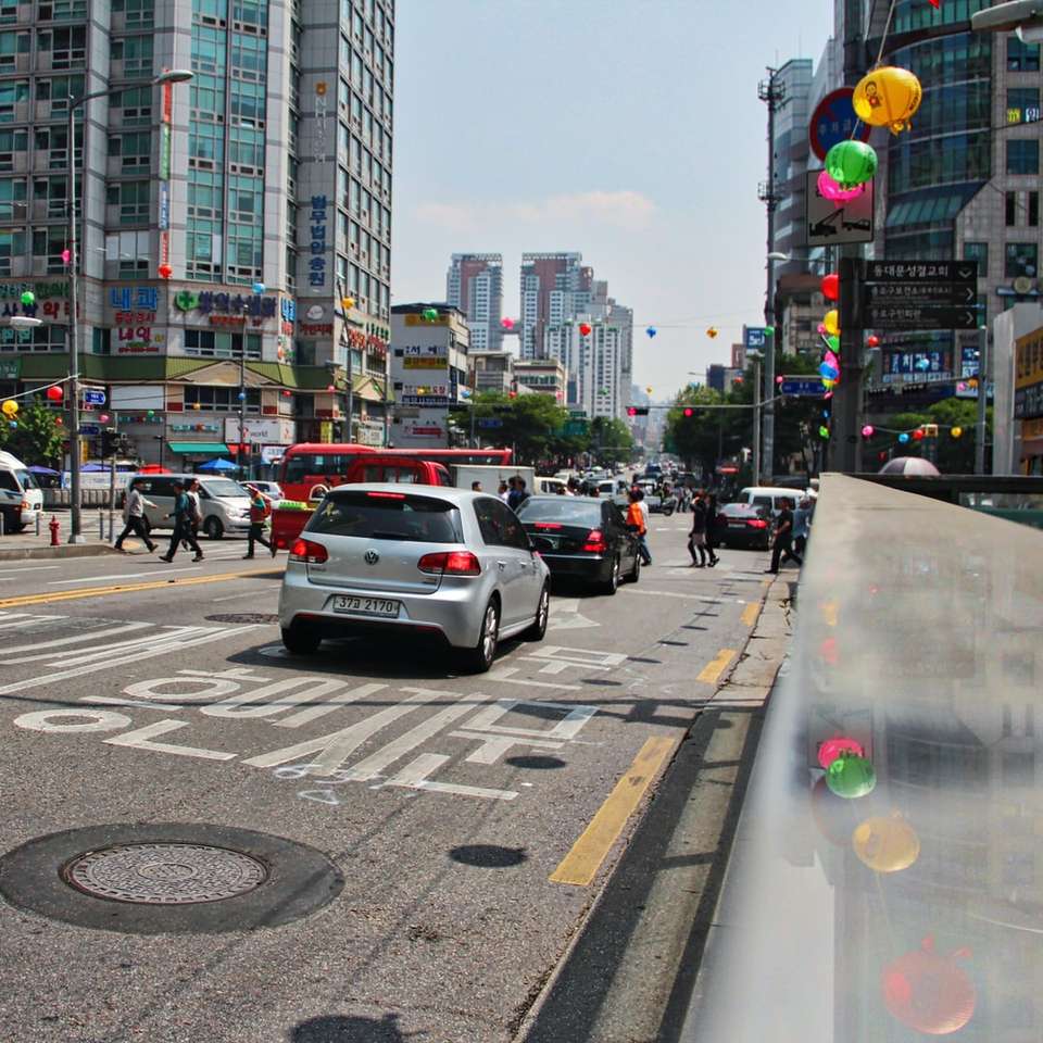 bilar på väg nära byggnader under dagtid glidande pussel online