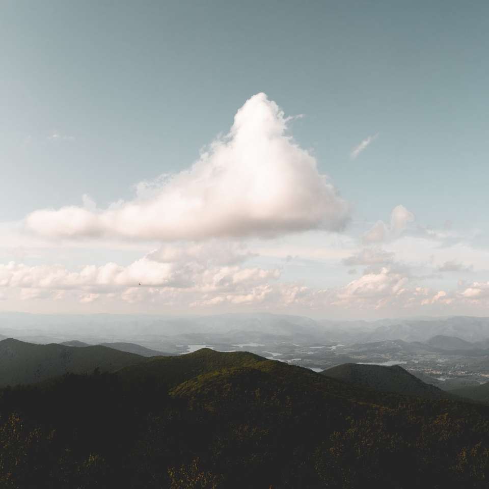 άσπρα σύννεφα πάνω από καταπράσινα βουνά συρόμενο παζλ online