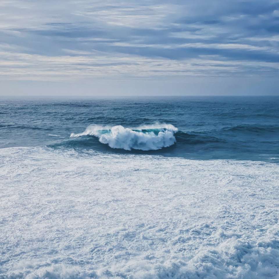 bílé mořské vlny na bílém písku během dne posuvné puzzle online