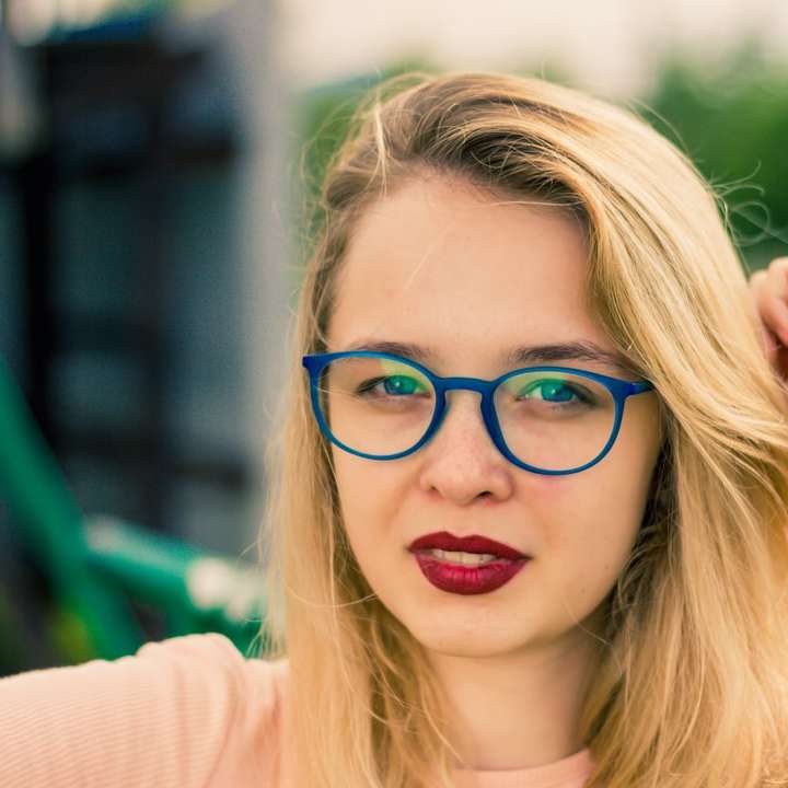 woman in blue-framed eyeglasses sliding puzzle online