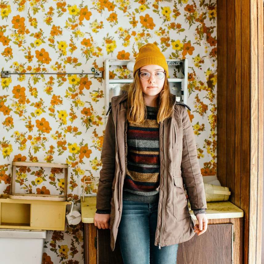 woman standing near cabinet in front of floral wallpaper online puzzle