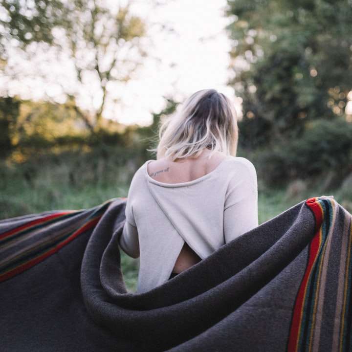 灰色の毛布を保持している立っている女性 スライディングパズル・オンライン