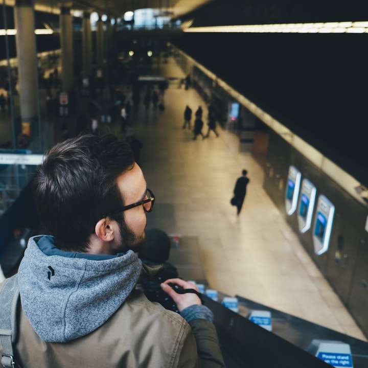 osoba stojąca na schodach ruchomych na stacji metra puzzle przesuwne online
