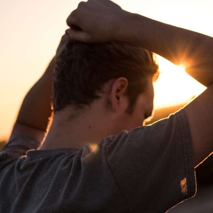 мужчина держит волосы против солнечного света онлайн-пазл