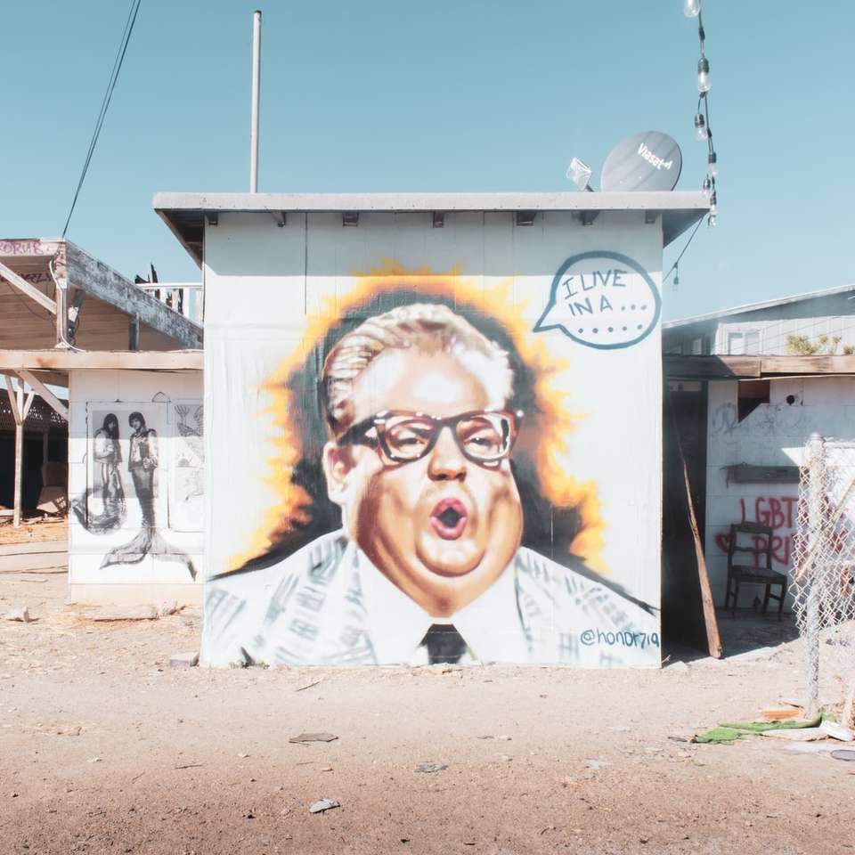 homem de camisa branca em pé ao lado de uma parede branca com grafite puzzle online
