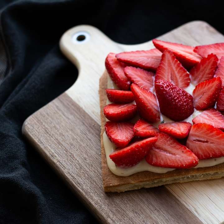 Tranches de fraises sur planche à découper en bois brun puzzle coulissant en ligne