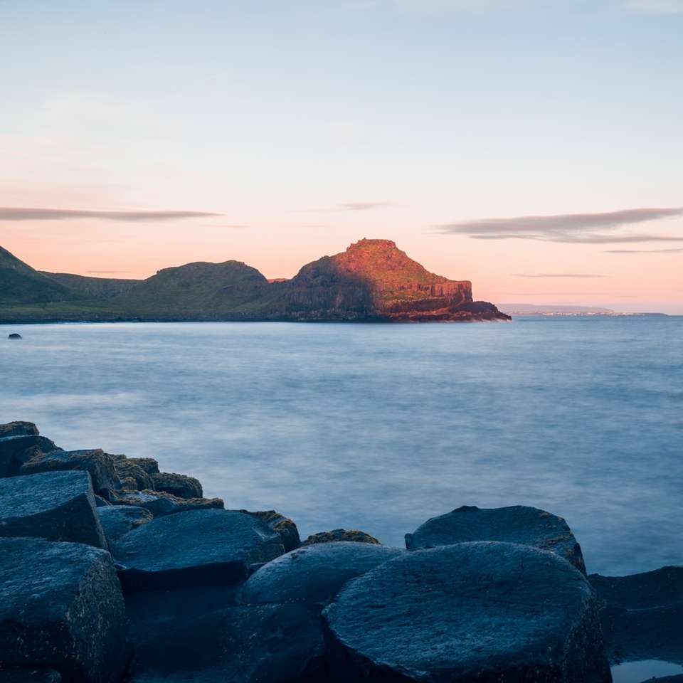 гірська скеля біля моря в денний час онлайн пазл