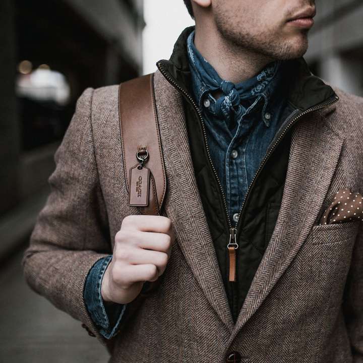 Homme en veste de costume marron portant sac à dos marron puzzle en ligne
