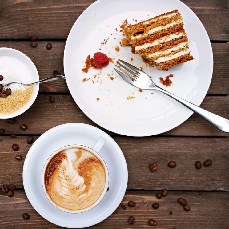 szelet tortát a tányéron, cappuccino mellett online puzzle