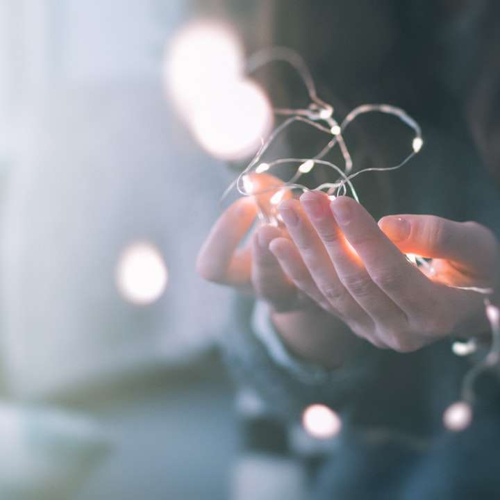 płytkie fokus zdjęcie osoby trzymającej łańcuchy świetlne puzzle online