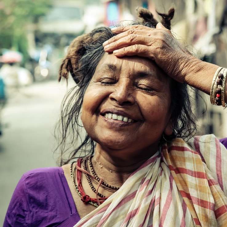 Nahaufnahmefoto der lächelnden Frau, die ihre Stirn hält Schiebepuzzle online