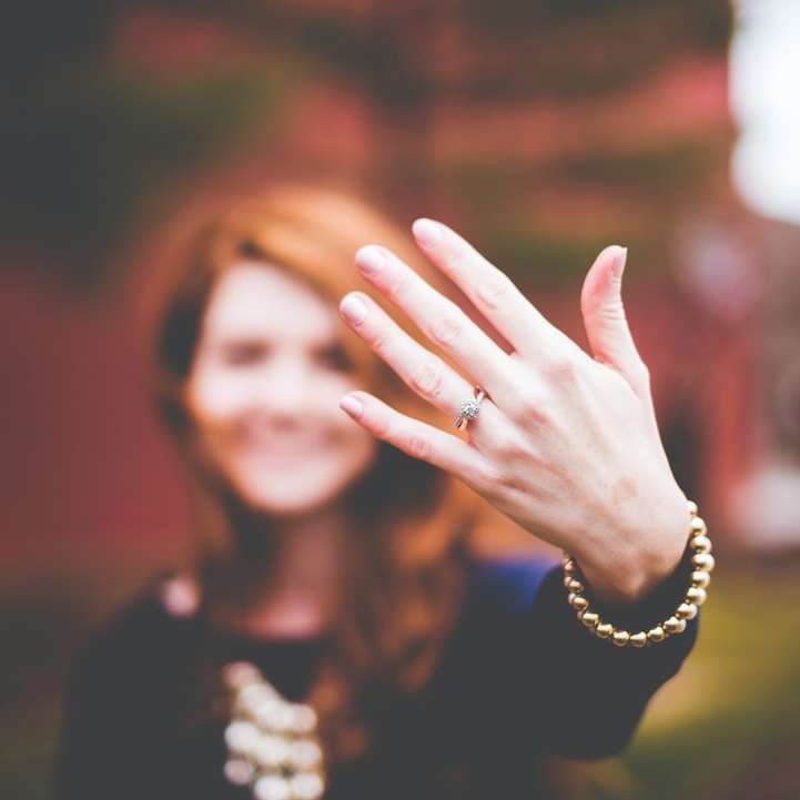 mujer mostrando anillo plateado rompecabezas en línea