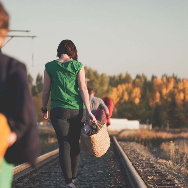 grupa ludzi chodzących po torach kolejowych podczas wschodu słońca puzzle online
