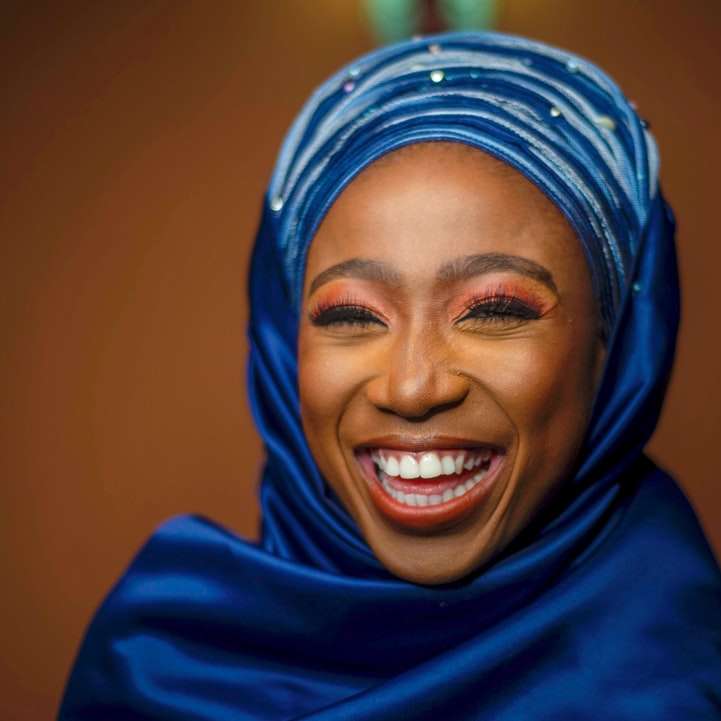 женщина в синем хиджабе улыбается онлайн-пазл