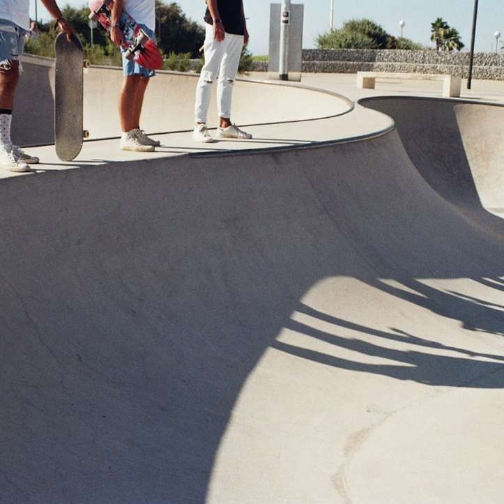 drie schaatsers staan ​​op skateboard betonnen oprit schuifpuzzel online