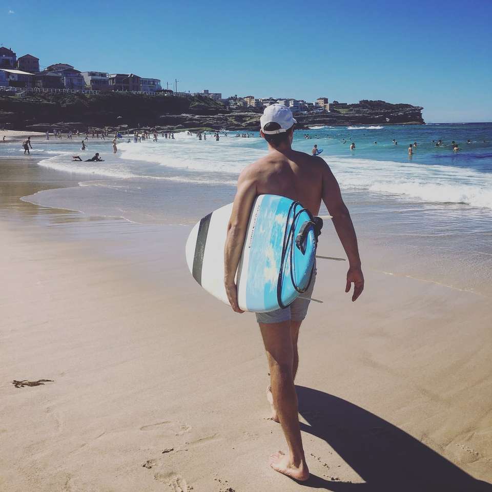 kvinna i blå och vit bikini som går på stranden glidande pussel online