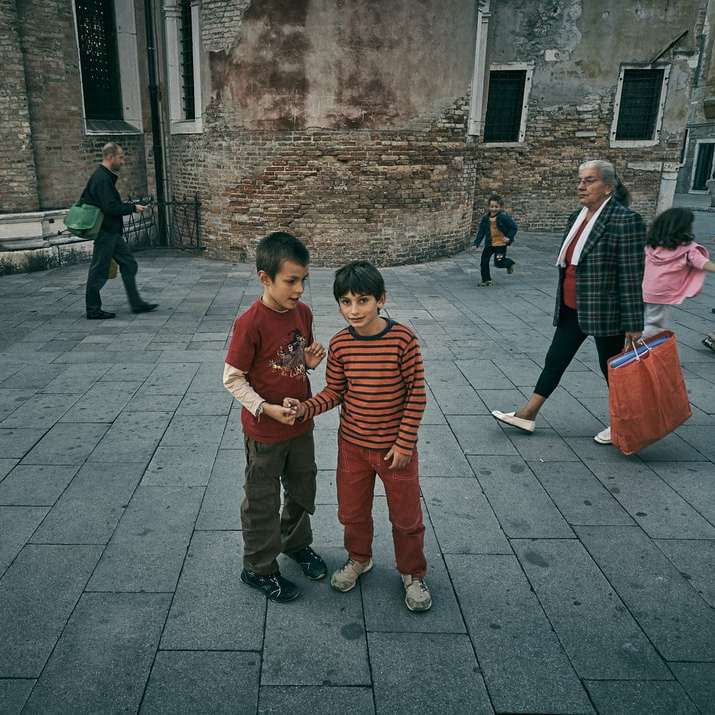 dois meninos parados na frente do prédio puzzle deslizante online