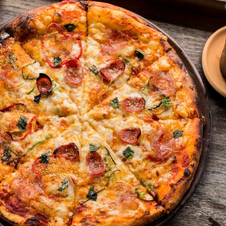 Draufsichtfoto der Peperoni-Pizza neben der braunen Tasse gefüllt Schiebepuzzle online