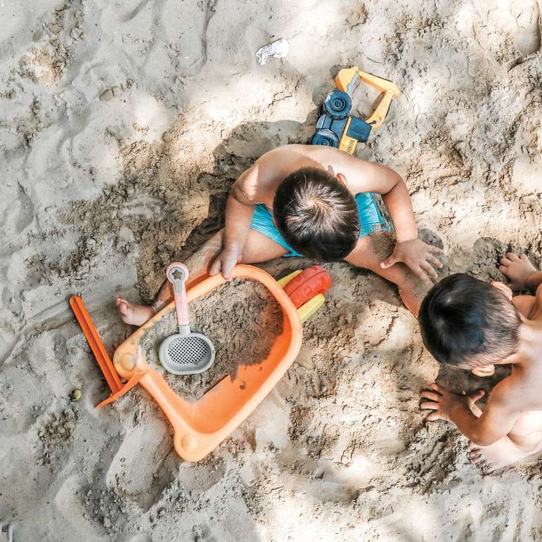 砂の上に座っている2人の男の子 オンラインパズル