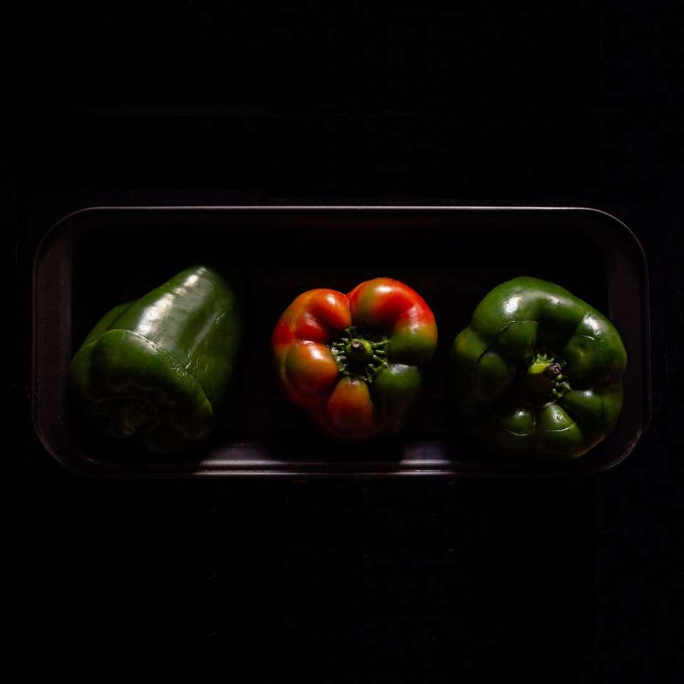 tre orange och gröna paprika på svart platta Pussel online