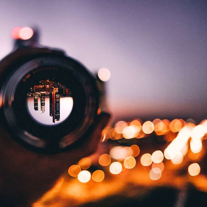 fotografia de foco superficial de pessoa segurando a lente da câmera puzzle deslizante online